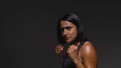 Studio-Portrait-Of-Mature-Woman-Wearing-Gym-Fitness-Clothing-Exercising-Sparring-At-Camera-3